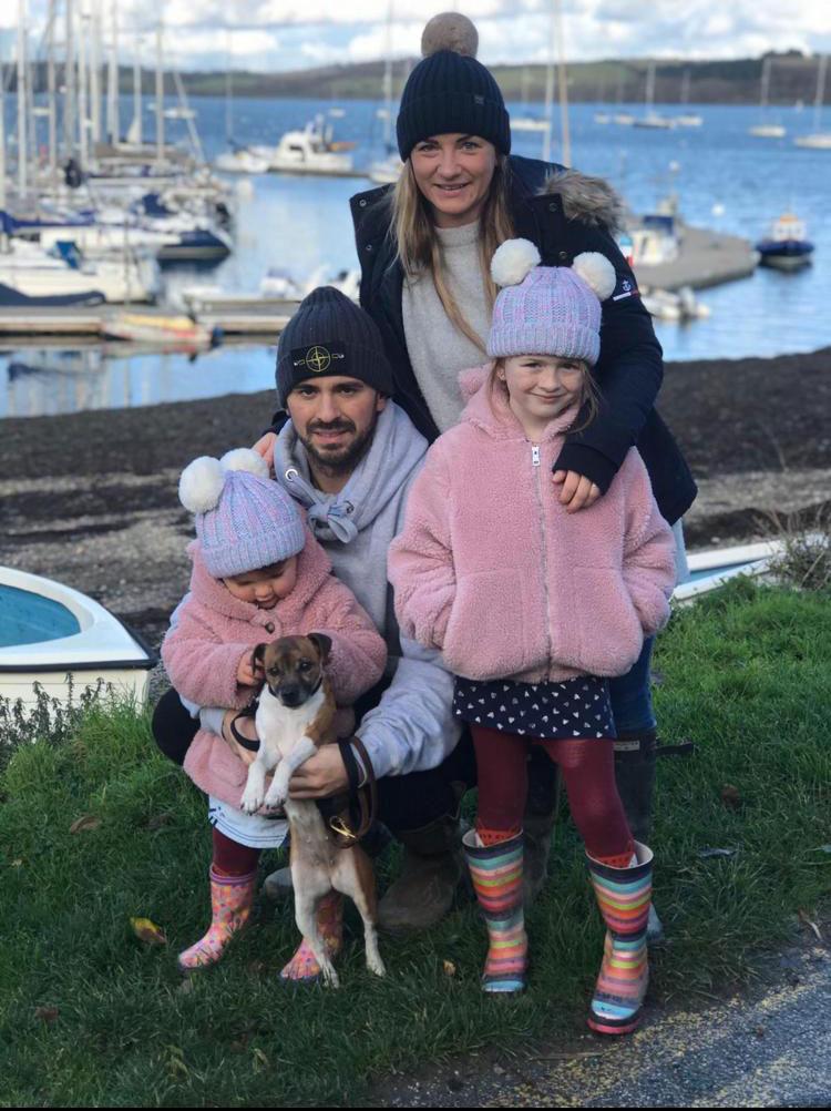 Family of four with their dog by a harbour