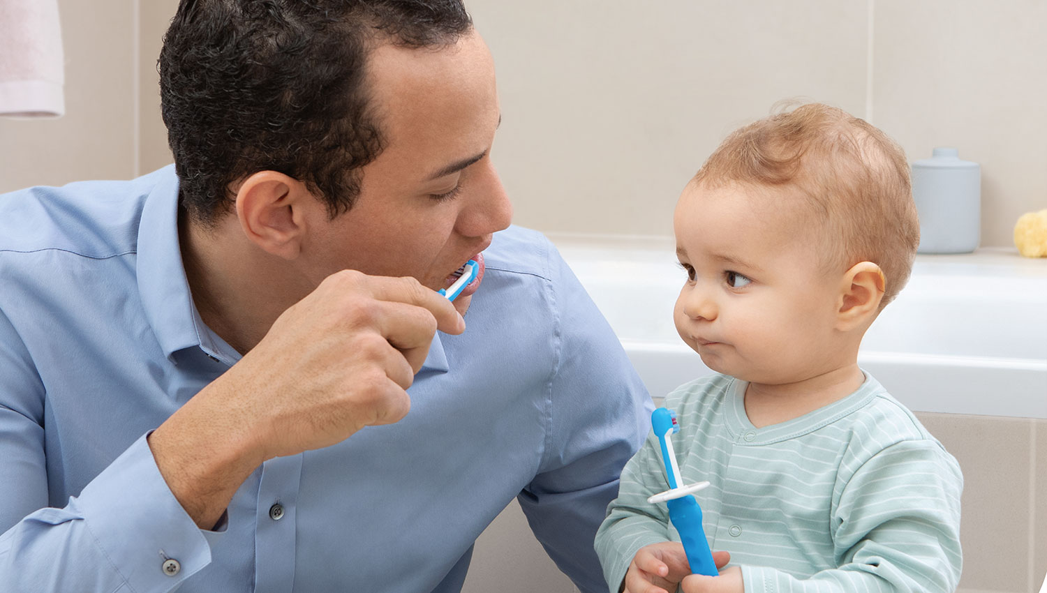 Dad brushing teeth with baby