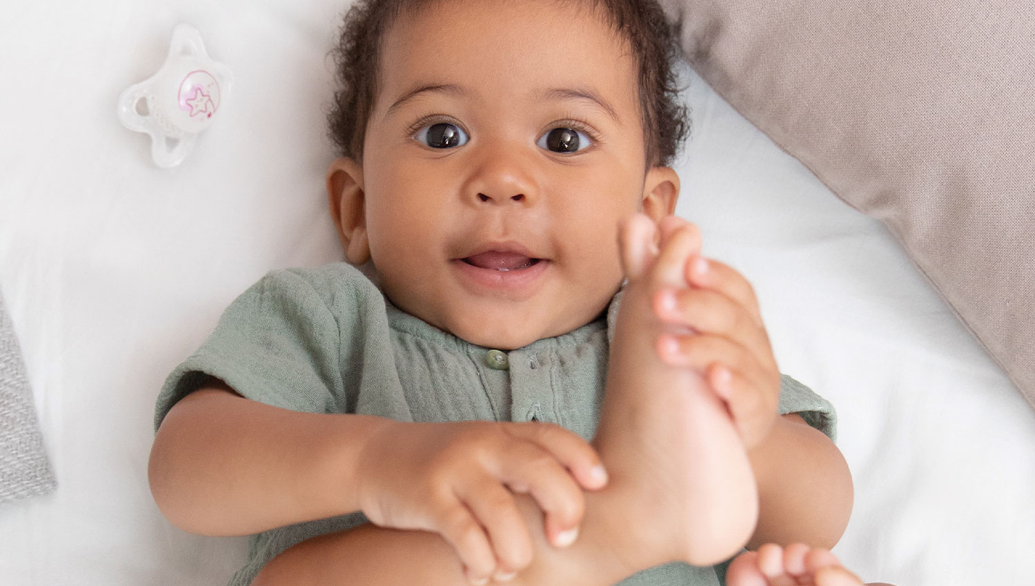 Baby holding foot